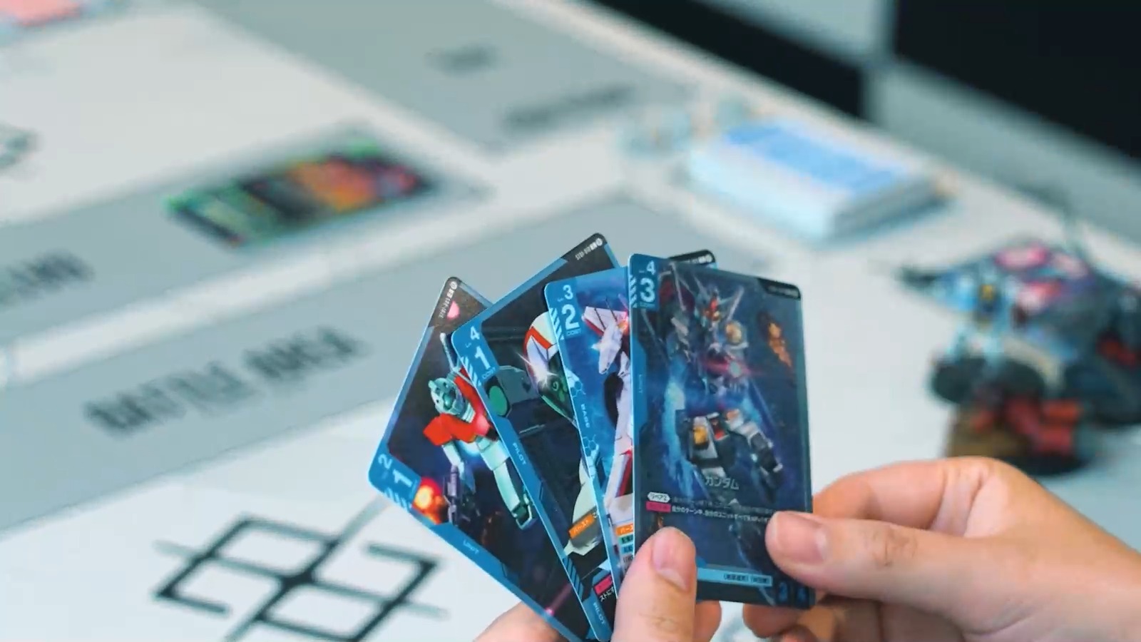 Gundam Card Game cards being played on a tournament mat